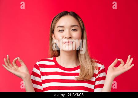 Pacifica felice rilassato donna asiatica meditating, tenere mani zen show orbs segno sorridente felice sollevato, sensazione di pazienza gioia pr Foto Stock