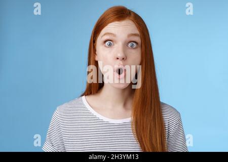 WOW omg affascinante. Impressionato sorpreso divertito buona-osservare redhead ragazza pieghevole labbra stupito occhi larghi storditi che reagiscono inc Foto Stock