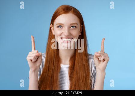 Divertito emozionato felice sorridente ragazza rossa guardare puntare su grinning volentieri guardando impressionante aria aperta perfomance in piedi joyfull Foto Stock