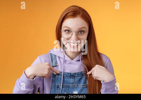 Sorpreso felice felice felice sorridente giovane ragazza redhead che ottiene la proposta impressionante grinning interrogato indicando lei ridendo Foto Stock