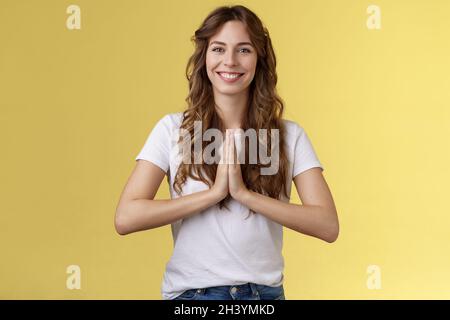 Amichevole felice rilassato buona donna osservare dire namaste sorridente ampiamente sollevato tatto bene che grinning positivo vibe premere palme toge Foto Stock