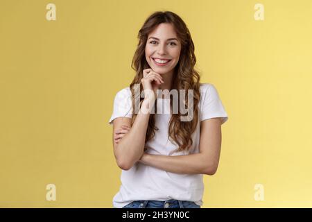 Tenero femminile entusiasta affascinante europea donna ricci capelli lunghi ridendo silly sguardo grinning joyfully toccare mento intri Foto Stock