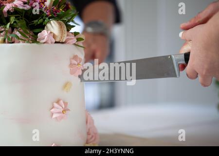 Dettaglio della sposa e lo sposo il taglio di torta di nozze dopo il matrimonio Foto Stock