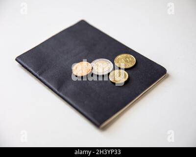 Primo piano del passaporto e delle monete su sfondo bianco. Foto Stock