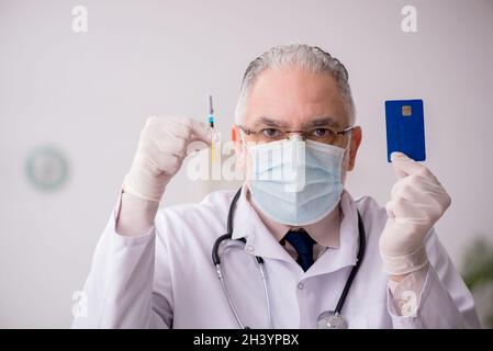 Vecchio medico di sesso maschile nel concetto di vaccinazione Foto Stock