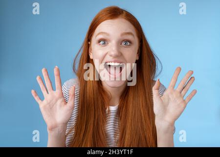 Eccitata carismatica felice vivace rossa giovane donna divertente sorridente entusiasta bocca aperta affascinato ampi occhi sorpresi fissando annuncio Foto Stock