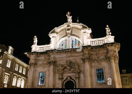 La facciata della Chiesa di Vlaha di notte, a Dubrovnik, Croazia, Europa. Finestre in vetro colorato con luce brillante. Foto Stock