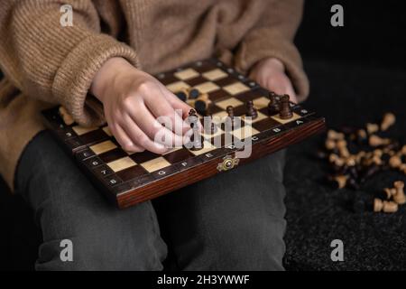 Donna che mette i pezzi di scacchi su una scacchiera. Foto Stock