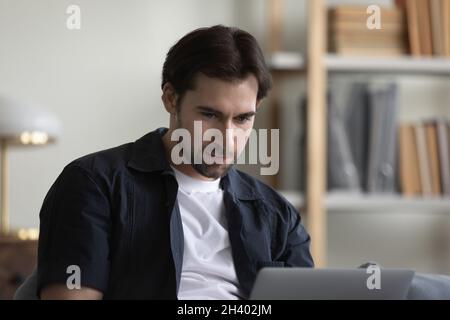Sorridendo bel giovane uomo che usa il computer a casa. Foto Stock