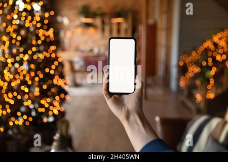 Primo piano della persona che utilizza lo smartphone a Natale Foto Stock