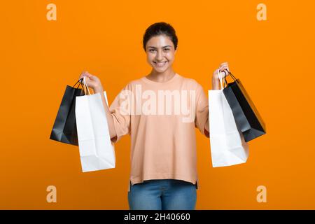 La donna indiana tiene i sacchetti di shopping nelle mani. Vendita e Black Friday. Foto Stock