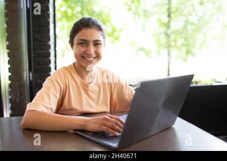 Donna d'affari indiana che lavora sul suo laptop all'aperto. Foto Stock