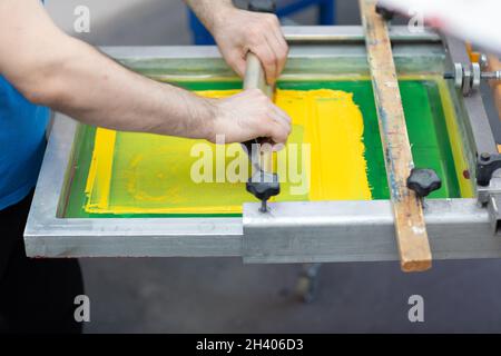 Serigrafia serigrafica processo di stampa presso la fabbrica di abbigliamento. Vernici a colori per telaio, spatola e plastisol Foto Stock