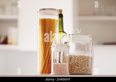 Prodotti alimentari in vasetti di vetro in cucina, pasta, cereali, sale, vino, generi alimentari Foto Stock