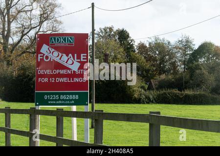 Sito di Greenfield con un cartello venduto, sito di sviluppo per 12 abitazioni nel villaggio di Bramley, Hampshire, Inghilterra, Regno Unito Foto Stock