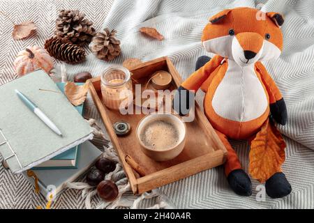 Higge ancora vita con un giocattolo volpe, una tazza di caffè, foglie d'autunno e un giornale Foto Stock