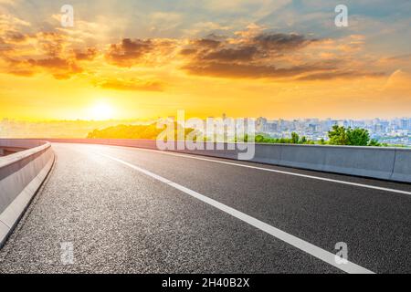 Strada asfaltata e skyline della città con edifici a Hangzhou all'alba. Foto Stock