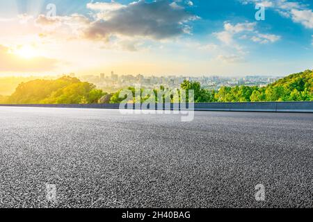 Strada asfaltata e skyline della città con edifici a Hangzhou all'alba. Foto Stock