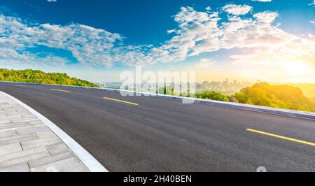 Strada asfaltata e skyline della città con edifici a Hangzhou all'alba. Foto Stock