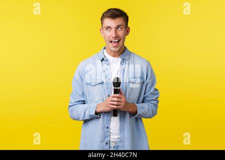 Stile di vita, emozioni della gente e concetto di svago estivo. Entusiasta felice bell'uomo biondo che guarda via e sorride, che parla o Foto Stock