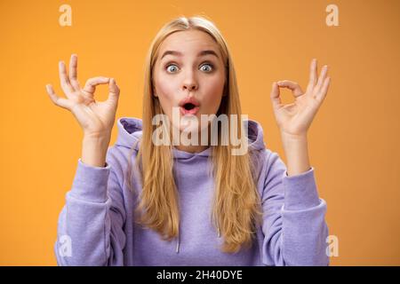 Divertente talento creativo giovane bionda femmina dire eccellente idea mostra OK nessun problema gesto persuadere gli amici tutto bene Foto Stock