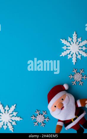 Christmass flatlay argenteo fiocchi di neve in forma cornice e divertente Babbo Natale giocattolo Foto Stock