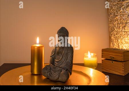 Spiritualità atmosfera sfondo con una statua di Buddha. Candele Foto Stock