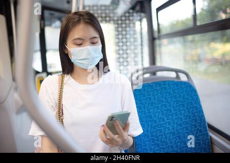Asian Woman fate un giro in autobus o tram con i mezzi pubblici. Foto Stock