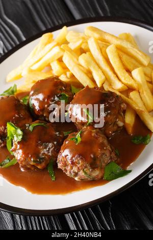 Boulets Liegeois è un piatto popolare servito in tutto il Belgio fatto di polpette di polpette che nuotano in un sugo di mela e cipolla servito con patate fritte primo piano nel pla Foto Stock