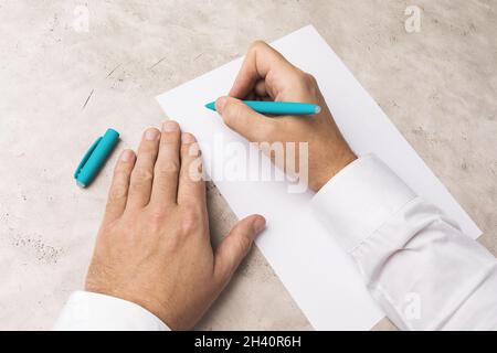 Un foglio di carta e una penna a sfera in mano, il concetto di scrittura della lettera Foto Stock