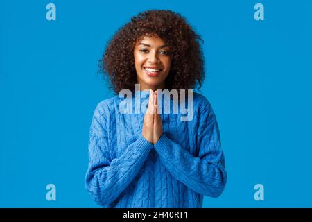 Grazie carina sorridente afroamericana graziosa donna con capelli afro, dicendo arigato e sorridente, stringe le mani insieme vicino che Foto Stock