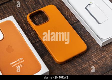 Antalya, Turchia - 28 ottobre 2021: Custodia in pelle Golden Brown MagSafe di nuova progettazione per Apple iPhone 13 Pro su sfondo in legno Foto Stock