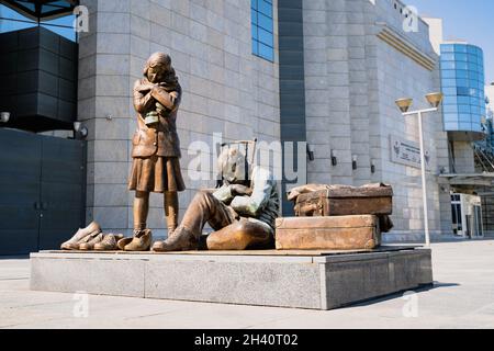 SKOPJE, NORTH MACEDONIA - 19 AGOSTO 2021: Statua del monumento in bronzo con bambini orfani di fronte al Museo dell'Olocausto Foto Stock