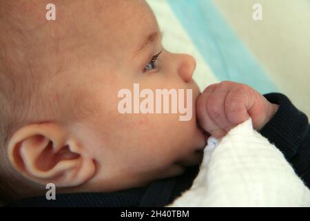 L'immagine ritratto del bambino che succhia le sue mani. Esplorare il suo corpo, sviluppare i suoi sensi o aiutare i denti a crescere. Foto Stock