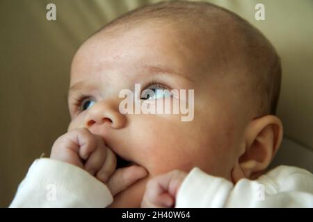 L'immagine ritratto del bambino che succhia le sue mani. Esplorare il suo corpo, sviluppare i suoi sensi o aiutare i denti a crescere. Foto Stock