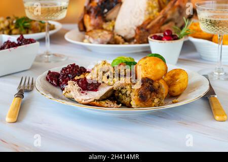 Tradizionale cena di Natale con tacchino arrosto, ripieno di albicocche e pistacchi, patate arrosto e salsa di mirtilli Foto Stock