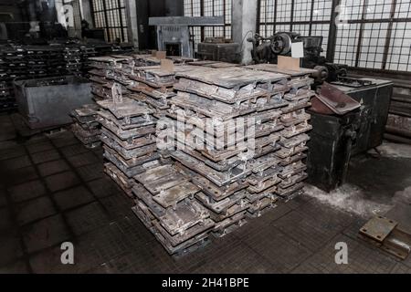 Parti in ferro del pezzo da lavorare per la posa di strutture metalliche di binari ferroviari in un cumulo in un impianto industriale. Foto Stock