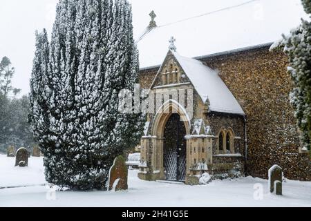 Chiesa di tutti i Santi nel piccolo villaggio di Sutton nella campagna britannica, è completamente coperto di neve profonda durante una rara tempesta di neve nel Regno Unito Foto Stock