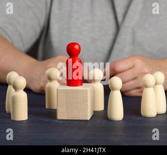 Figurina rossa di legno scelta dalla folla. Il concetto di trovare dipendenti di talento, manager, crescita della carriera. Assunzione del personale Foto Stock