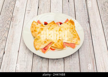 Le quesadillas messicane di prosciutto e formaggio sono una ricetta semplice e gustosa, ideale per una cena o un antipasto Foto Stock