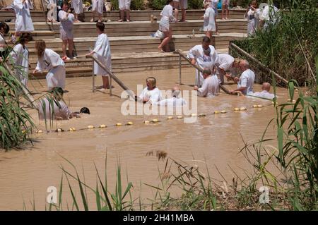 Cristiani che nuotano e sono battezzati nel fiume Giordano, Betania, Giordania, Medio Oriente Foto Stock