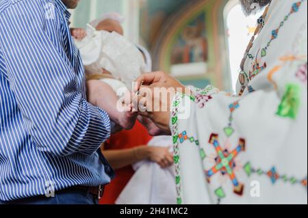 sacramento del battesimo il sacerdote battezza il bambino con l'unzione Foto Stock