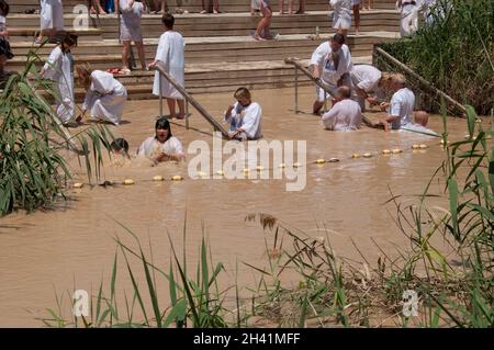 Cristiani che nuotano e sono battezzati nel fiume Giordano, Betania, Giordania, Medio Oriente Foto Stock