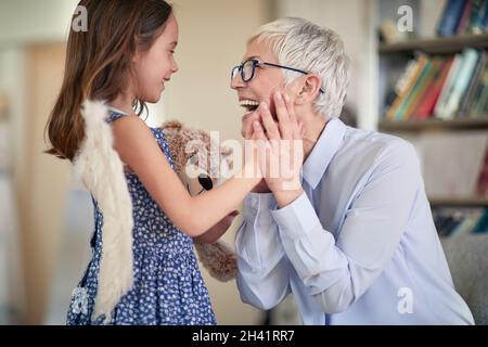 Una nonna allegra è così felice mentre trascorre un tempo meraviglioso con la nipote in un'atmosfera familiare a casa. Famiglia, casa, amore, divertimento Foto Stock