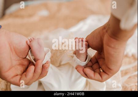 il bambino piccolo piede il bambino sul braccio del padre Foto Stock