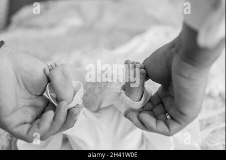 il bambino piccolo piede il bambino sul braccio del padre Foto Stock