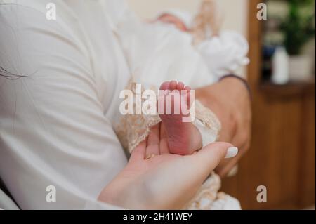 sacramento del battesimo il sacerdote battezza il bambino con l'unzione Foto Stock