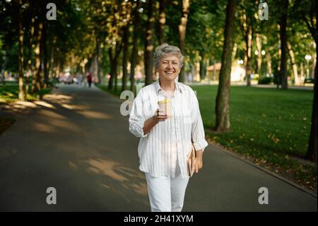 Divertente caffè Granny drink nel parco estivo Foto Stock