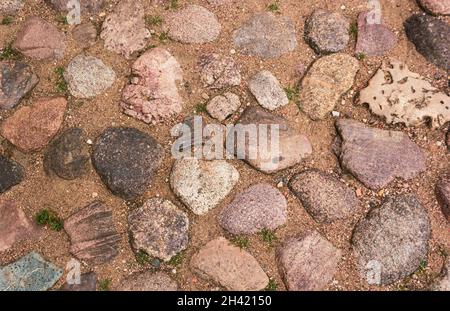 Pavimentazione in pietra con pietre tonde. Antichi marciapiedi in Europa Foto Stock
