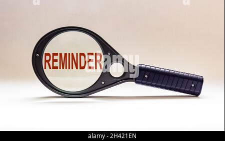 Promemoria, testo su lente di ingrandimento e sfondo bianco. Foto Stock